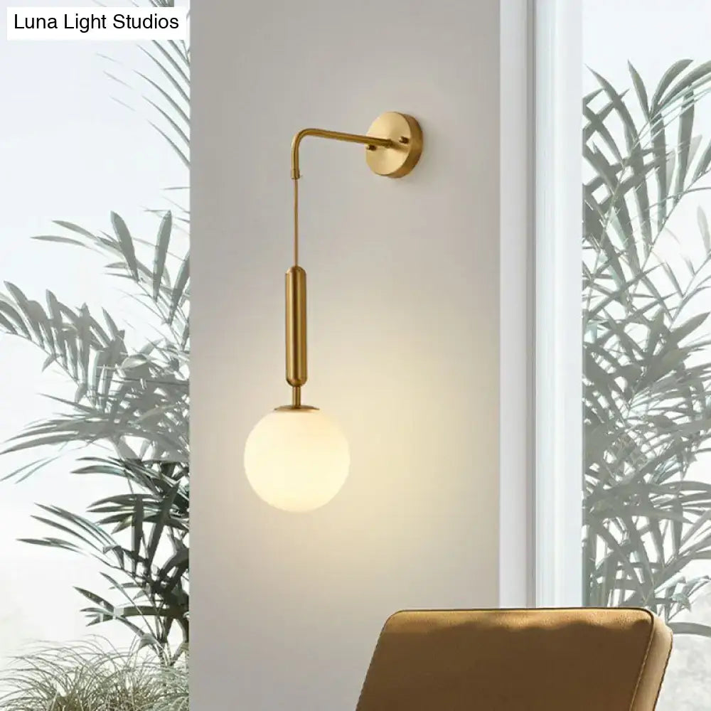 Minimalist wall light with a gold finish and cream frosted glass shade for bedroom sconce lighting