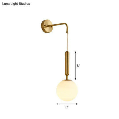 Minimalist wall light with gold finish and cream glass spherical shade for bedroom sconce lighting