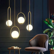 Minimalist gold glass ball led chandelier features gold-toned pendant lights with frosted glass ball shades and oval frames