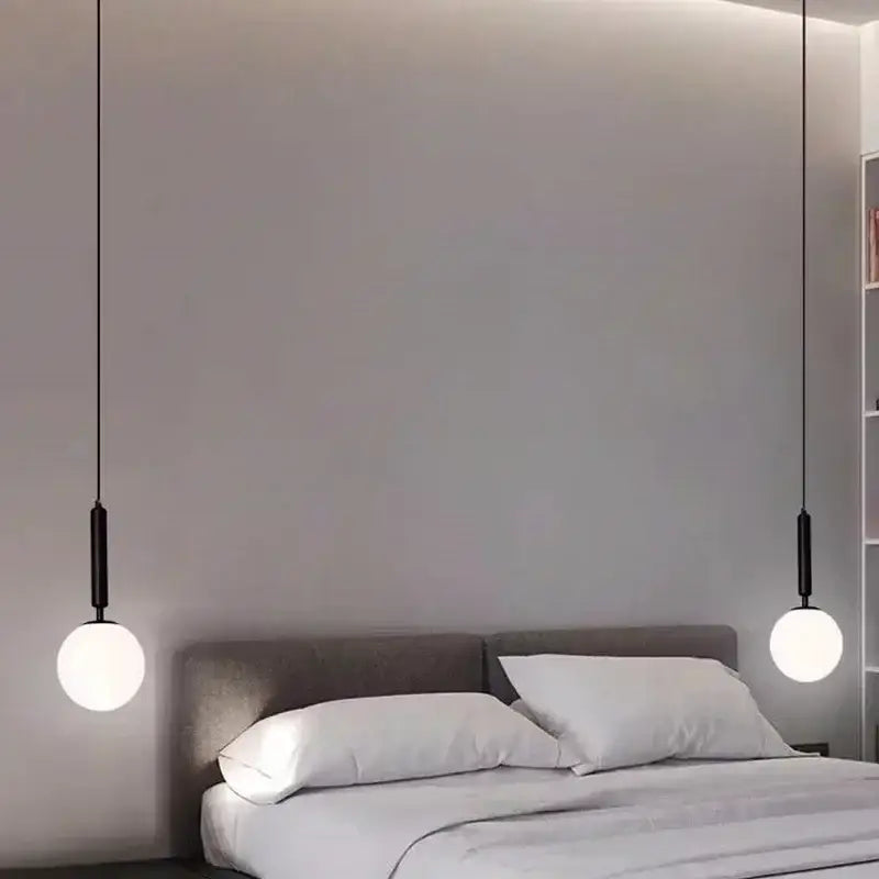 Modern black pendant chandelier with spherical white glass ball led shades hanging symmetrically above bed decorbites glass ball