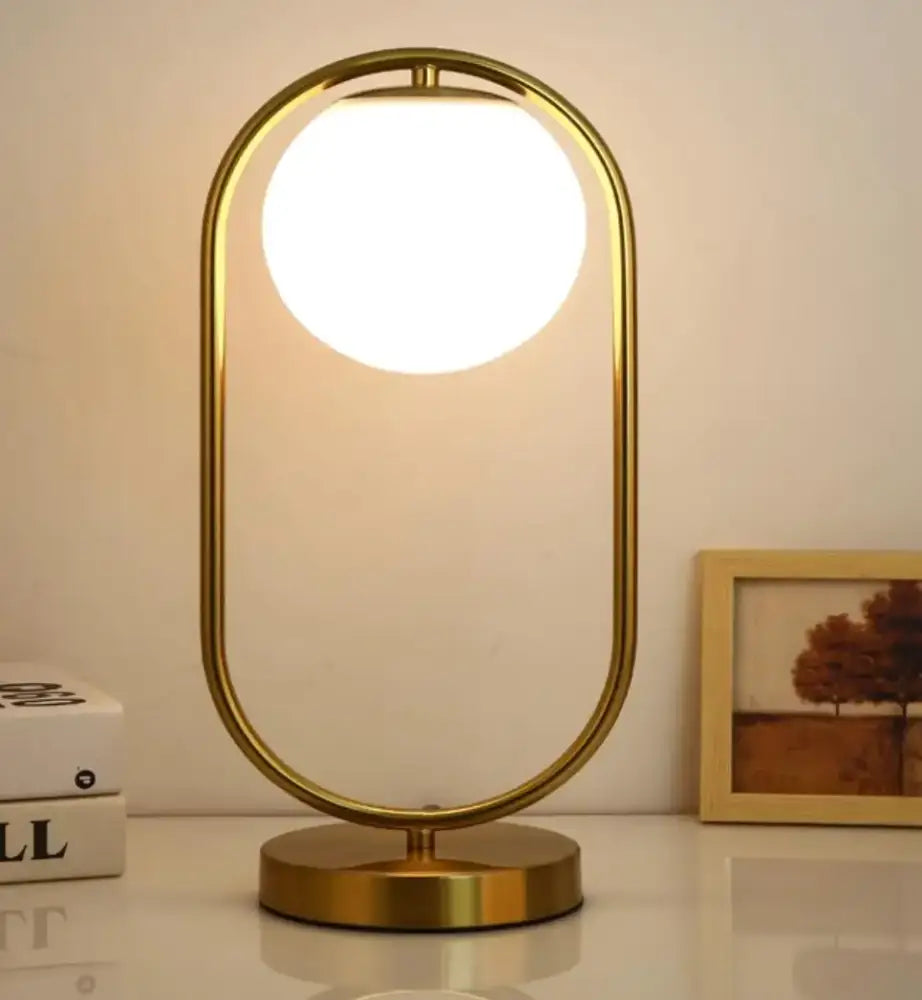 Minimalist gold-toned oval glass ball led table lamp with glowing bulb for bedroom decor by decorbites glass ball