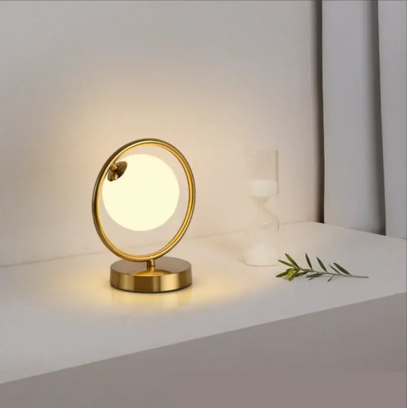 Minimalist gold-toned table lamp with frosted glass ball led globe and metallic base for decorbites bedroom decor