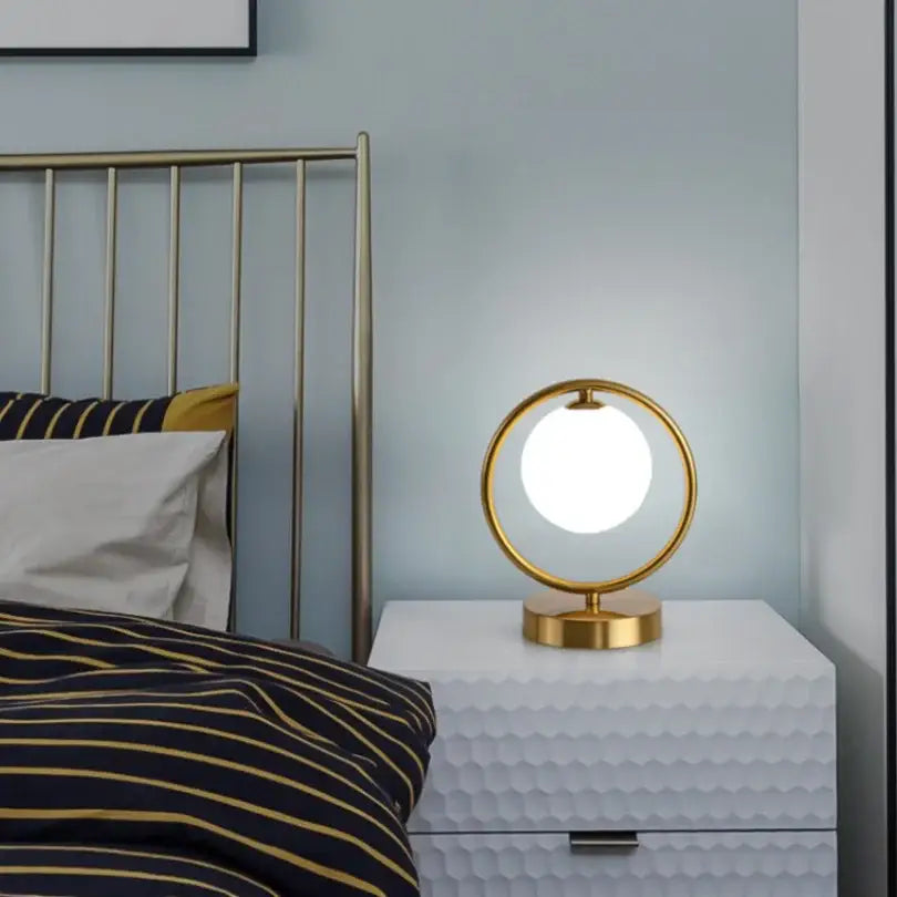 Minimalist gold-toned table lamp with glowing white glass ball led and sleek metallic base for bedroom decorbites decor