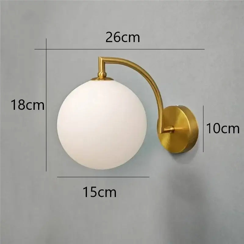 Minimalist gold wall sconce with a frosted white glass ball shade for bedroom wall lamp lighting