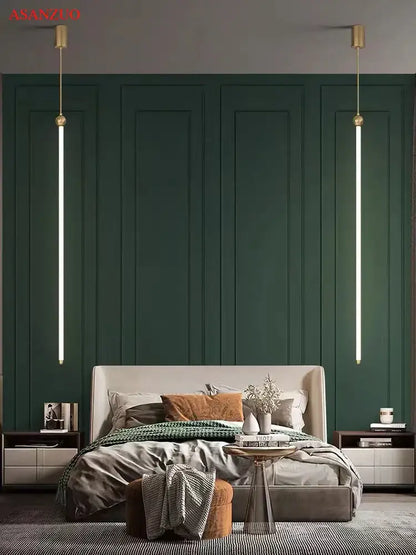 Minimalist gold led strip pendant lights hanging symmetrically over a deep emerald green paneled wall and modern bed decorbites led strip