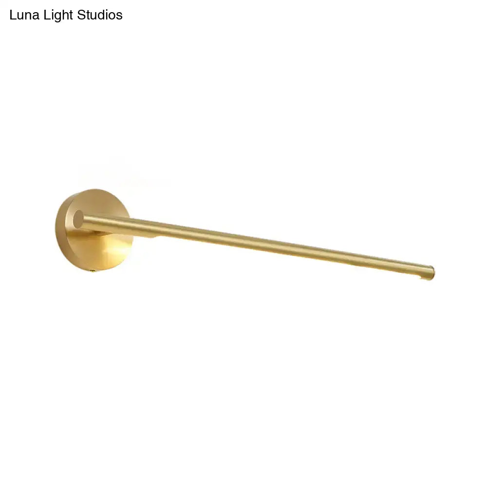 Brass-finished wall-mounted towel rack with minimalist design paired with a gold led wall light with acrylic diffuser