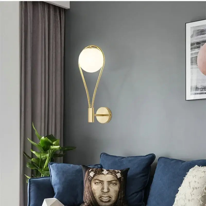 Minimalist gold wall lamp with curved metal frame and frosted glass ball golden shade for living room decorbites glass ball