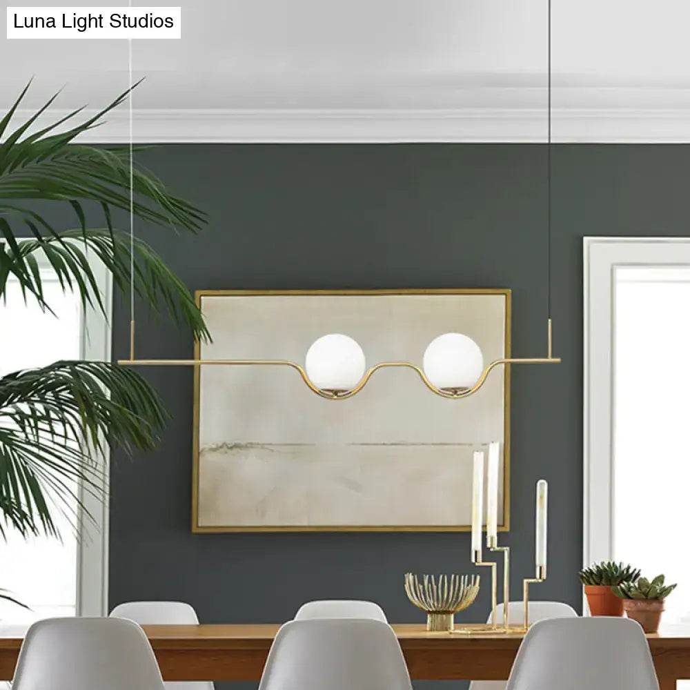 Minimalist gold metal island pendant ceiling light with modern brass fixture and two white glass globes for dining table
