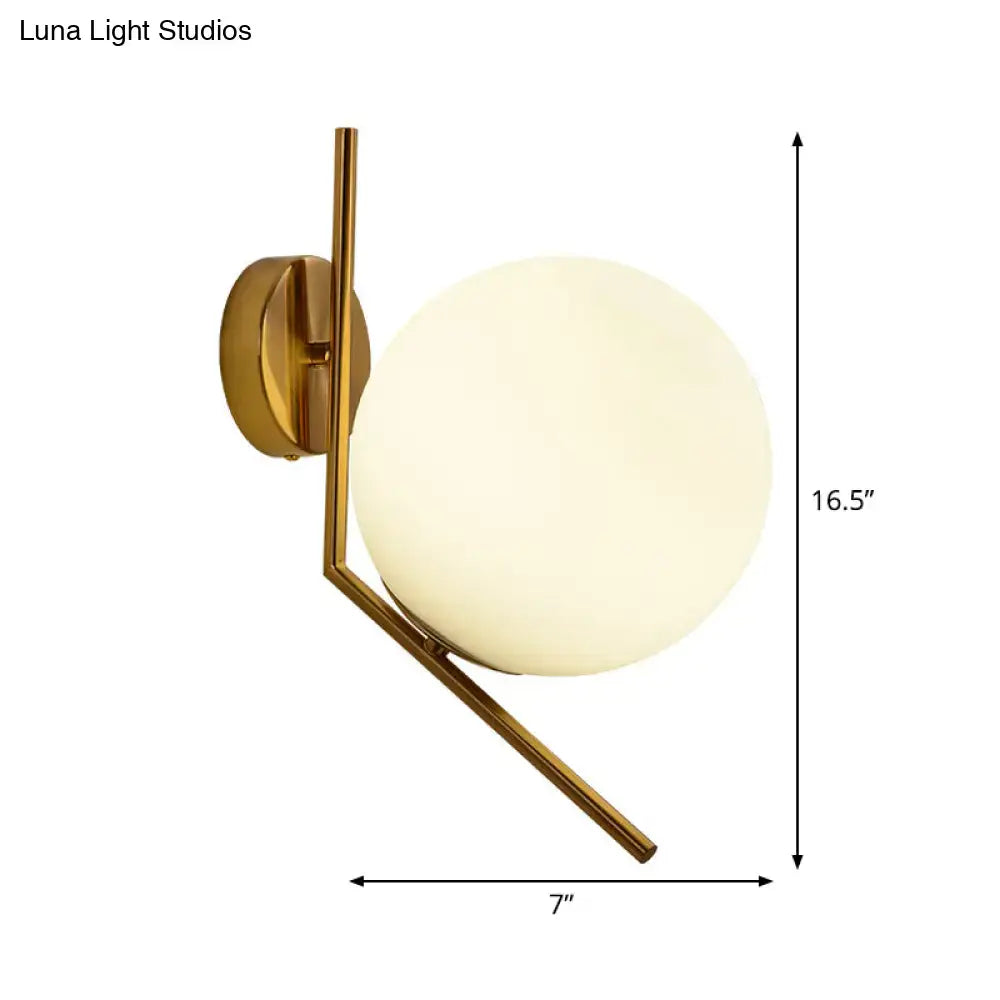 Gold mini globe wall sconce with sleek gold-toned metal arms and a frosted glass globe for minimalist bedroom lighting