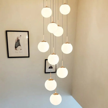 Minimalist Gold Multi-Pendant Ceiling Light with Cream Glass Bubbles and White Glass Staircase Suspension