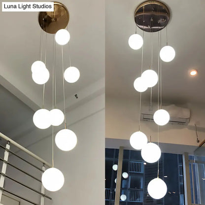 Minimalist Gold Multi-Pendant Ceiling Light with Cream Glass Bubbles and White Glass Staircase Suspension