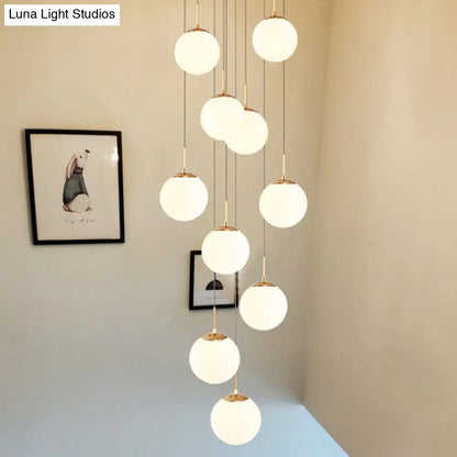 Minimalist Gold Multi-Pendant Ceiling Light with Cream Glass Bubbles and White Glass Staircase Suspension