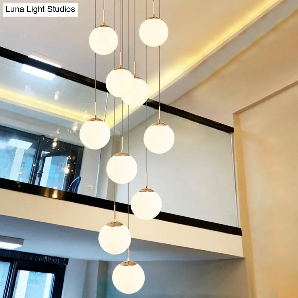 Minimalist Gold Multi-Pendant Ceiling Light with Cream Glass Bubbles and White Glass Staircase Suspension