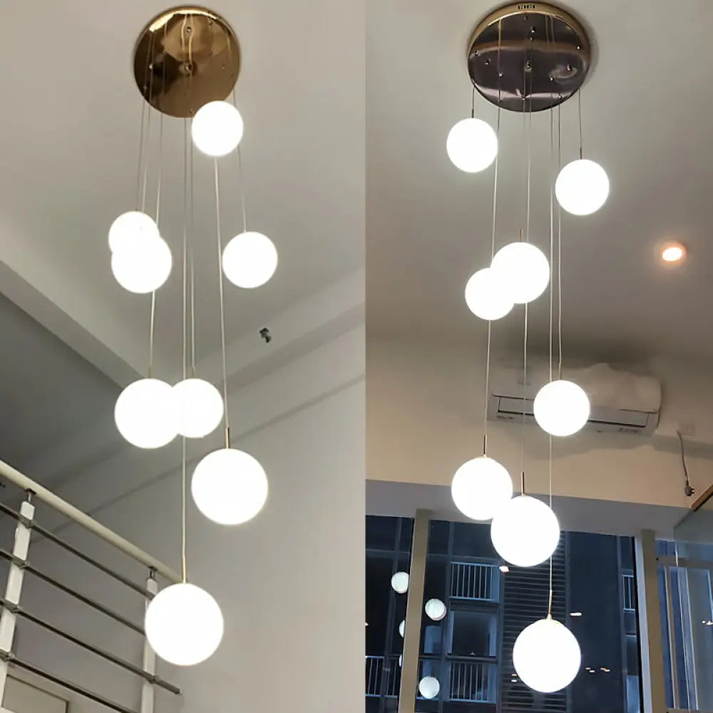 Minimalist Gold Multi-Pendant Ceiling Light with Cream Glass Bubbles and White Glass Staircase Suspension