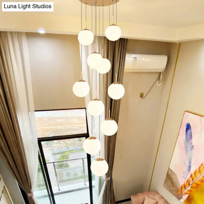 Minimalist Gold Multi-Pendant Ceiling Light with Cream Glass Bubbles and White Glass Staircase Suspension