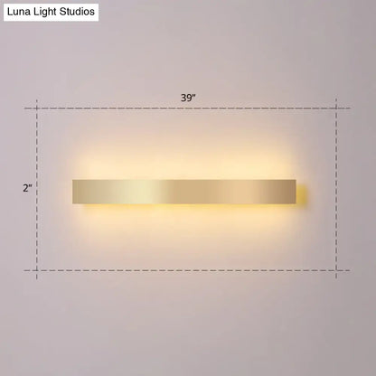 Minimalist gold plated led wall sconce with a sleek rectangular design and warm ambient lighting for living rooms