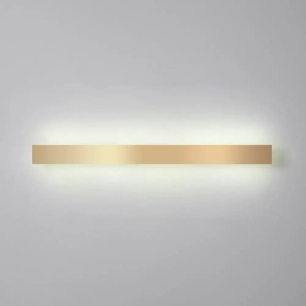 A sleek minimalist gold plated led wall sconce with a rectangular design for living room or bar lighting