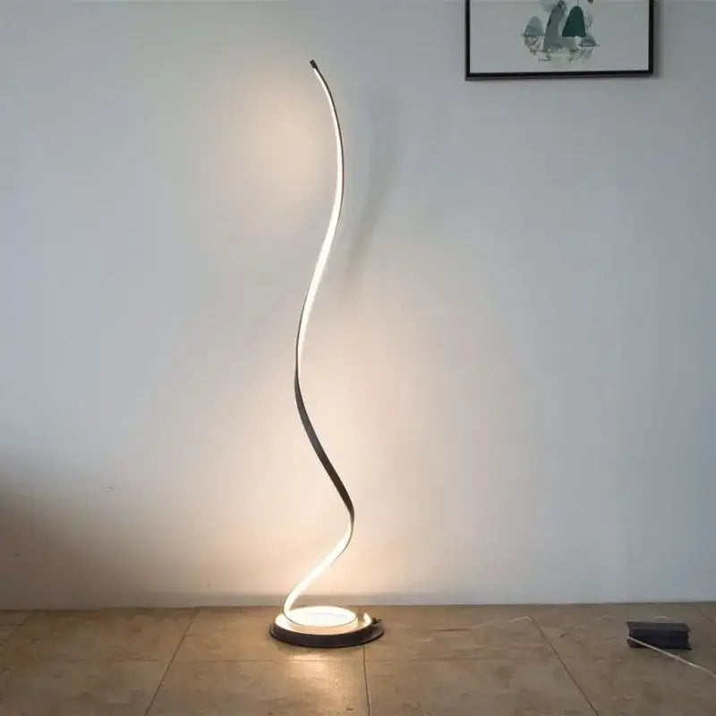 Minimalist standing lamp with a sleek gold curved design emitting warm white LED light for living room use