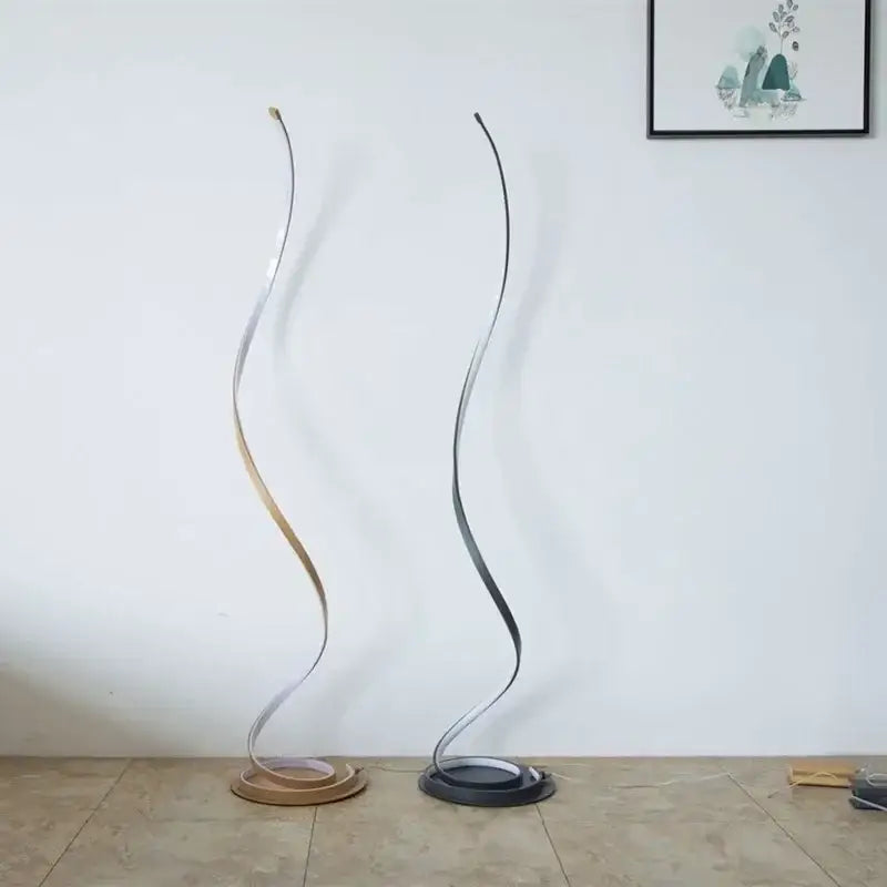 Two elegant minimalist standing lamps with metallic finishes in brushed silver and matte black on circular bases