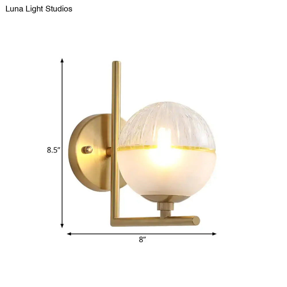 Brass-finished minimalist wall lamp with textured glass globe and frosted lower half 8-inch fixture for bedroom lighting