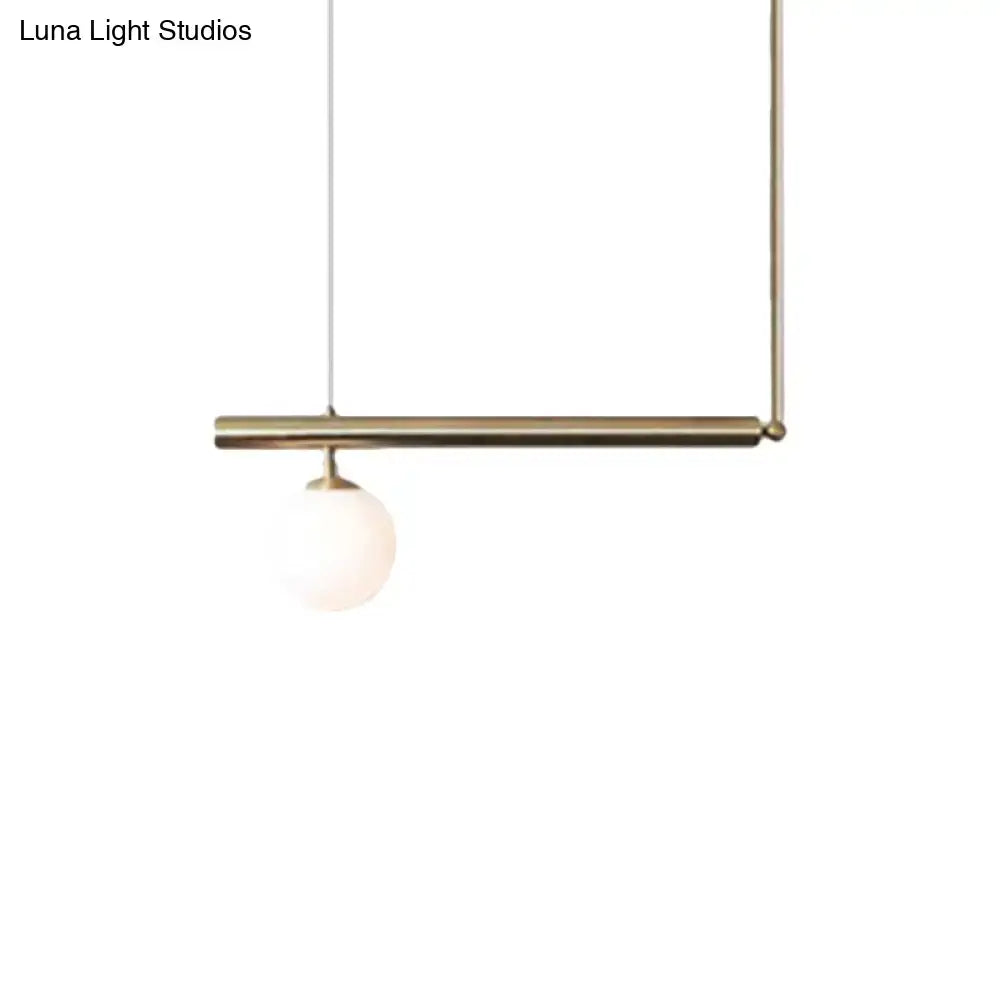 Minimalist brass DecorBites™ pendant light with spherical frosted glass bulb for dining room illumination