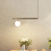Minimalist brass pendant light with spherical frosted glass bulb from DecorBites™ for dining room chandelier