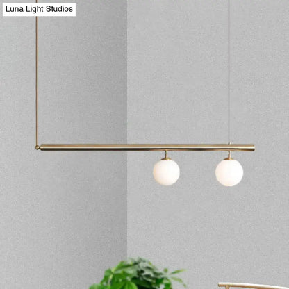 DecorBites™ modern brass pendant light with two white glass globes for dining room lighting