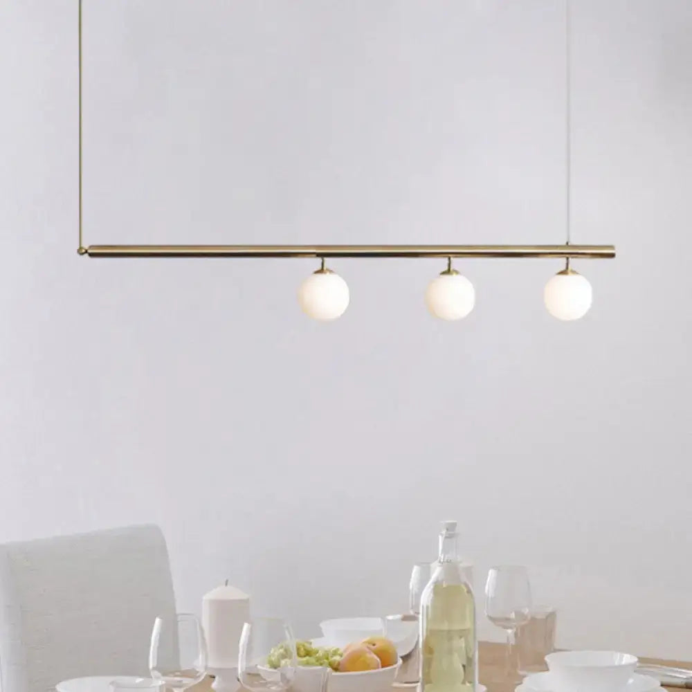 Modern brass decorbites™ pendant light with three frosted glass bulbs for stylish dining room illumination