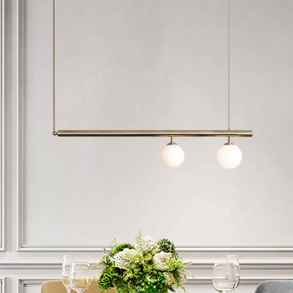 Modern brass pendant light with two white glass globes from DecorBites™ ideal for dining room lighting