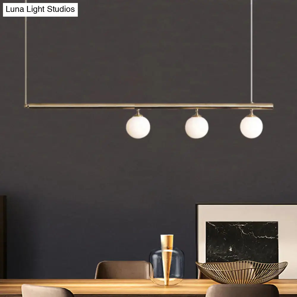 Modern minimalist DecorBites™ golden glass shade hanging lamp with brass bar and white globes for dining room lighting