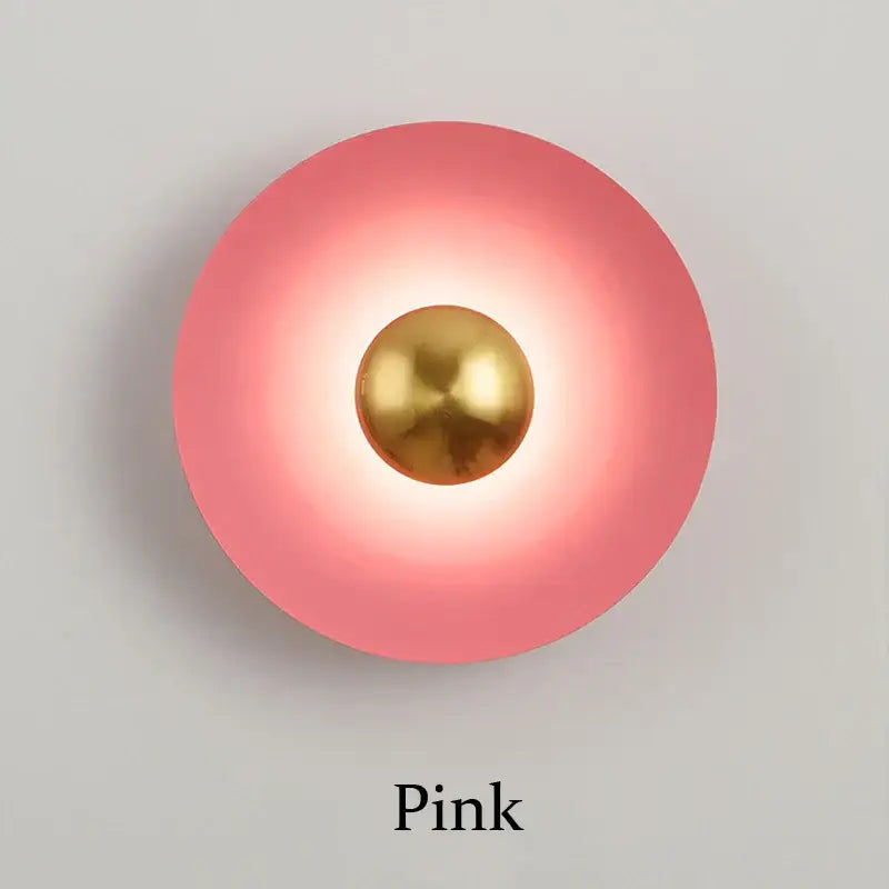 Minimalist golden macaroon led wall lamp featuring a pink spherical sconce with a central gold-toned metallic sphere for bedroom decorbites decor