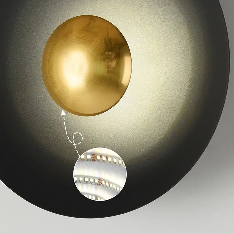 A sleek matte black wall lamp with a golden spherical bulb from decorbites golden macaroon led collection