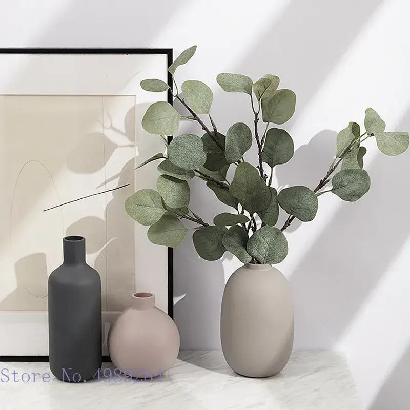 A sleek beige matte ceramic vase with eucalyptus branches part of decorbites colorful ceramic vase living room decor
