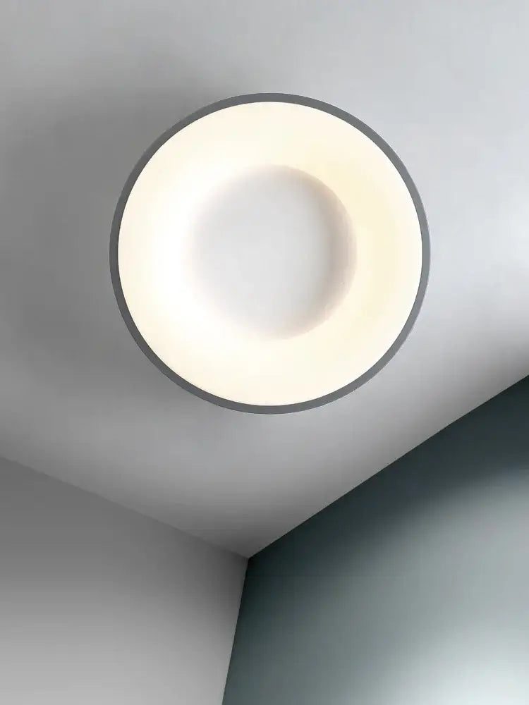 Minimalist gray round dining room ceiling lamp with a sleek metallic rim and soft white illuminated center ceiling lamp