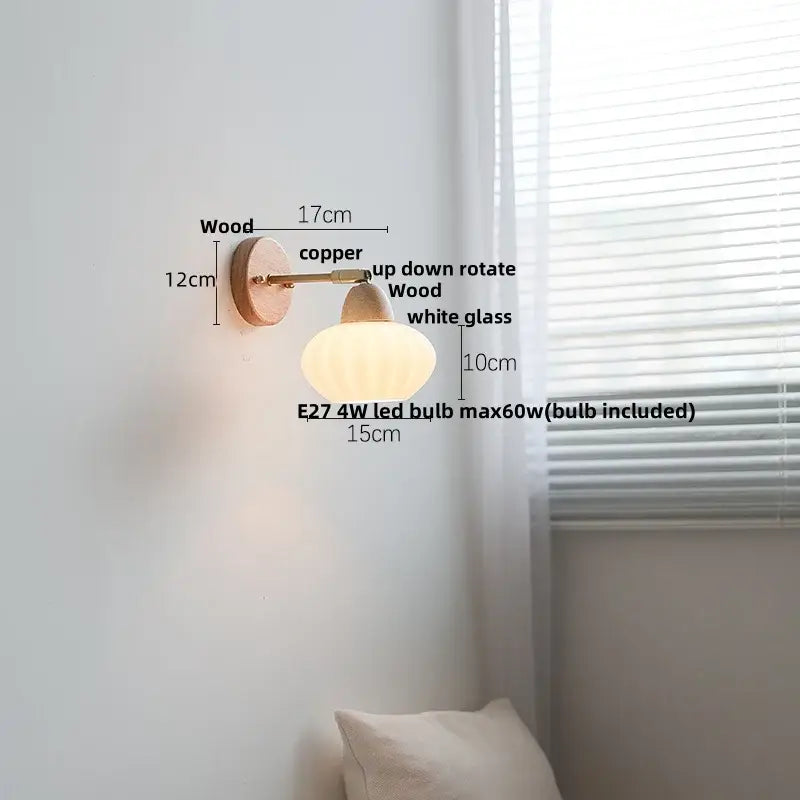 A warm-toned minimalist iron wood led wall lamp with wooden base copper arm and white glass shade for bedroom decorbites