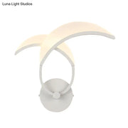 White crescent moon-shaped double curved minimalist led wall sconce providing warm white light for bedroom use