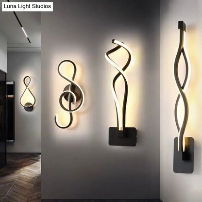 Minimalist line art sconce light fixture featuring sleek twisted black metal design with warm white LED light for hallways