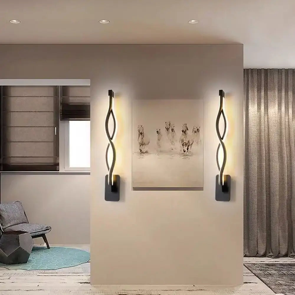 Minimalist line art sconce light fixture in black metal with sleek twisted design emitting a warm glow for hallways