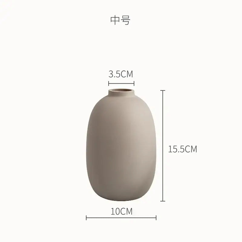 A matte beige minimalist decorbites geometric ceramic vase with rounded shape and narrow neck for living room decor