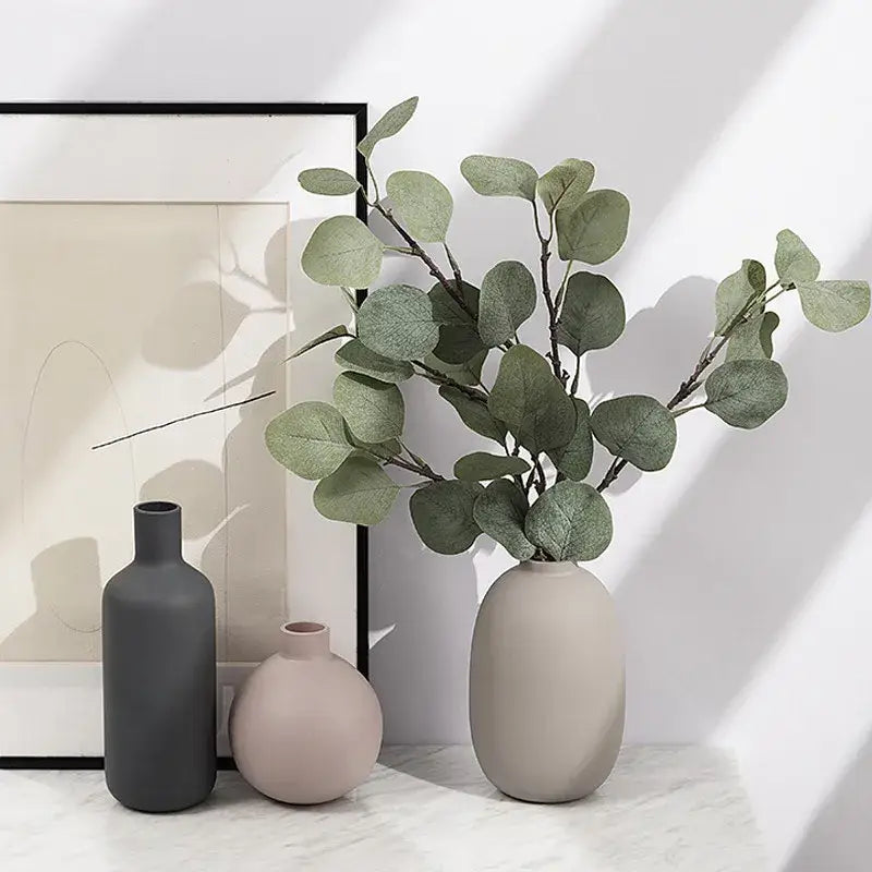 Minimalist matte pastel beige geometric ceramic vase by decorbites holding artificial eucalyptus for living room decor