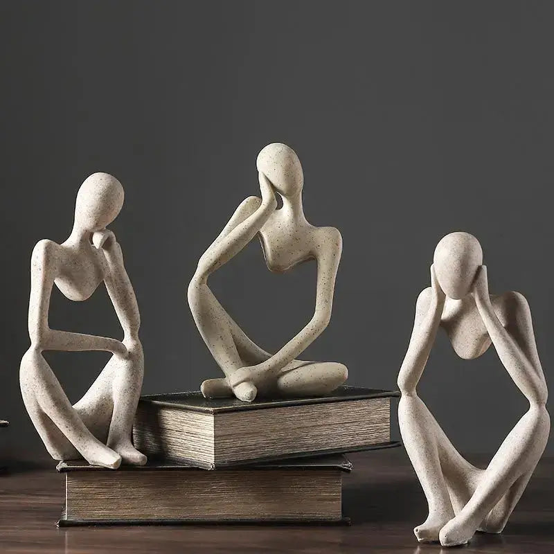 Three abstract beige ceramic thinker woman figurines in contemplative poses for minimalist living room decor