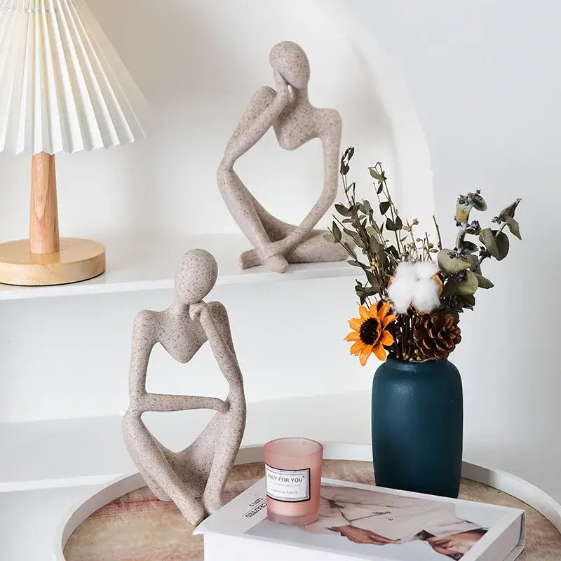 Two abstract thinker woman figurines crafted from speckled beige resin with minimalist contours for living room decor