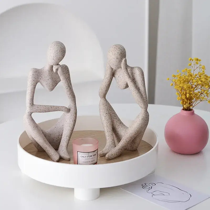 Two minimalist matte white abstract thinker woman ceramic figurines with speckled texture for living room decor