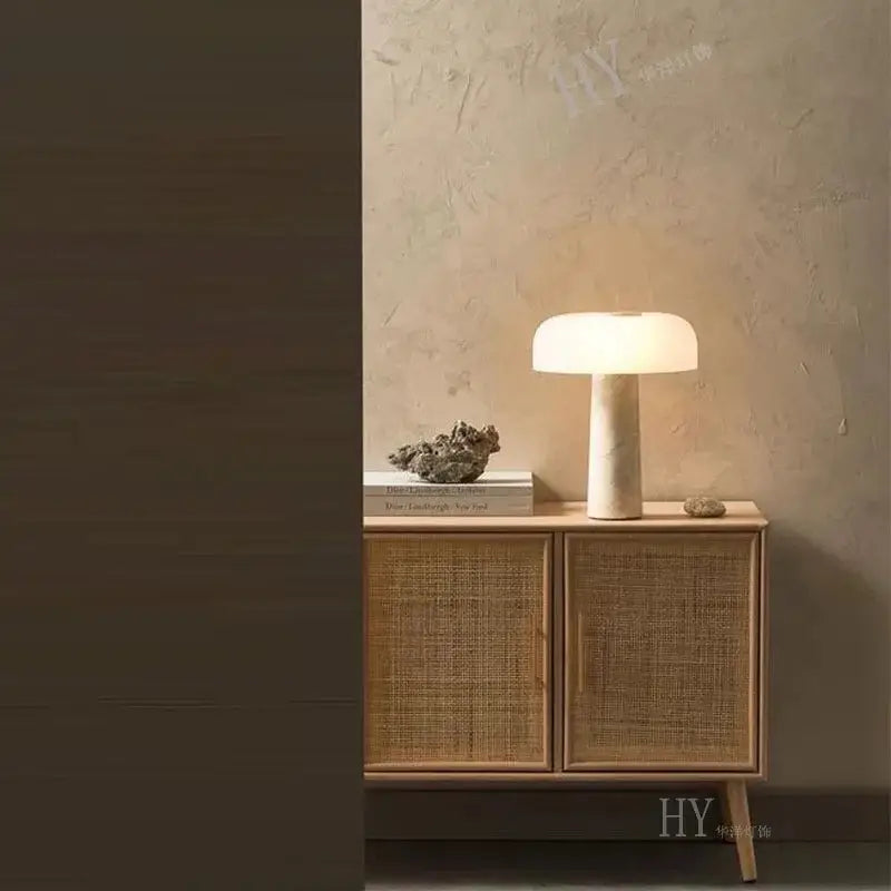 Cream-colored minimalist mushroom cave stone table lamp with frosted glass dome shade and slender base for bedroom decorbites cave stone table