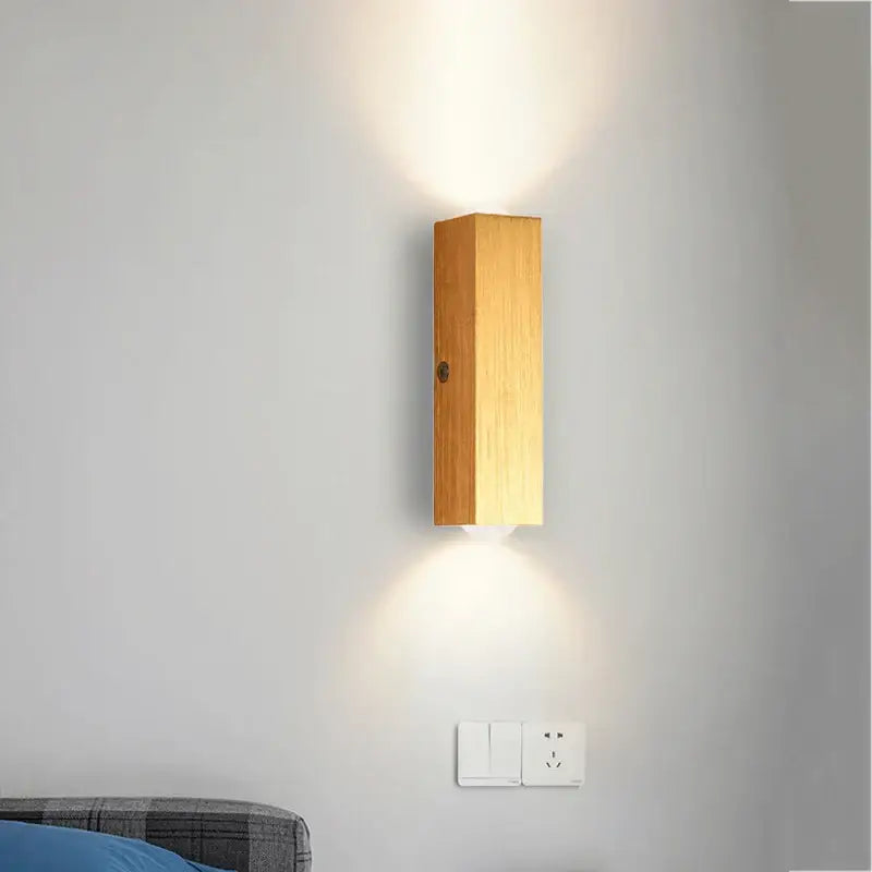 Minimalist natural wood wall lamp with angled design and warm glow for bedroom decor featuring decorbites brushed gold finish