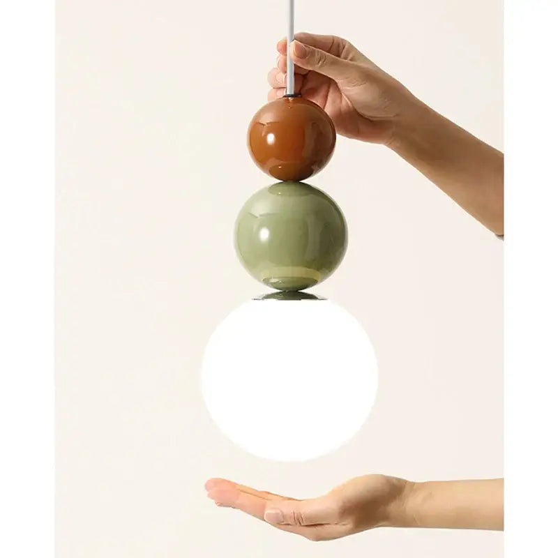 Minimalist nordic pendant light with three glossy terracotta and sage ceramic spheres and a white glass globe for bedroom decorbites cream style