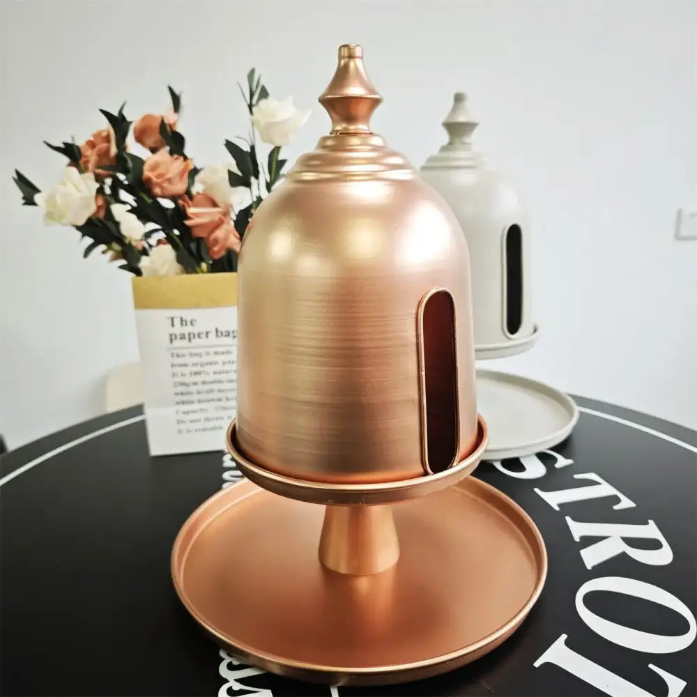 Copper-colored metal paper towel dispenser with domed top and vertical slot as a decorbites creative paper storage solution
