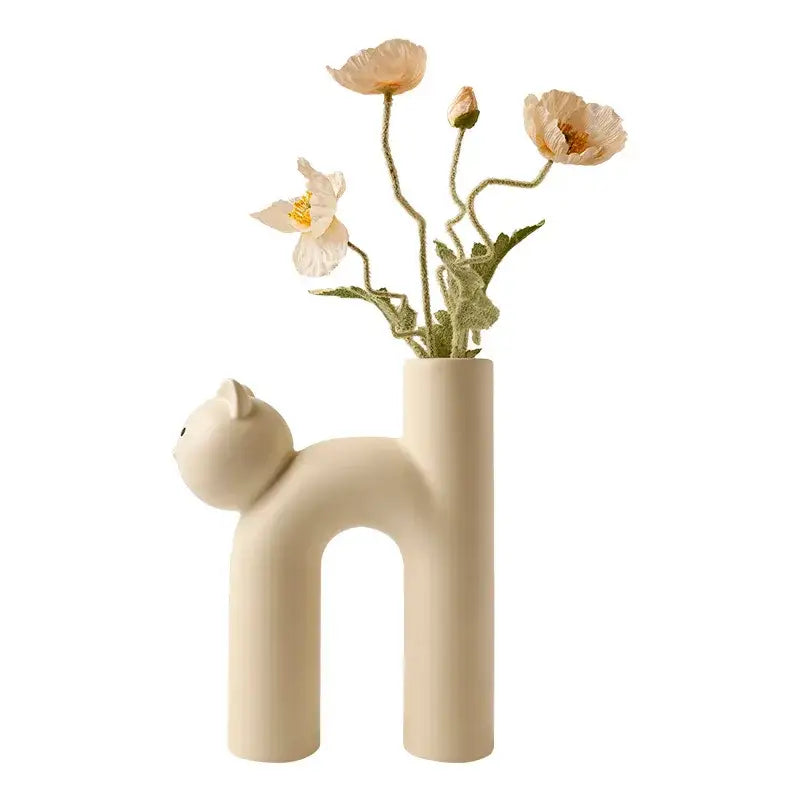 Minimalist off-white ceramic decorbites cathead h-shaped tube vase shaped like a stylized cat holding pale pink poppies