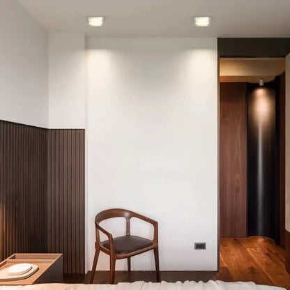 Minimalist wooden chair with dark brown frame and black leather seat under decorbites crystal dimmable led spot light