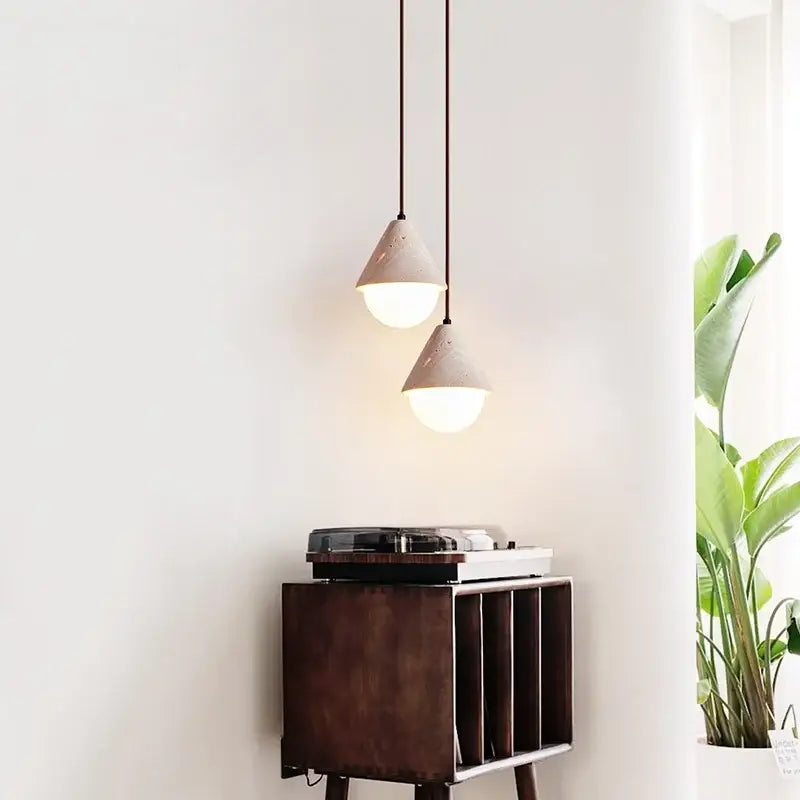 Minimalist off white creative stone led pendant light with matte concrete shades and warm glow above record player decorbites creative stone pendant light